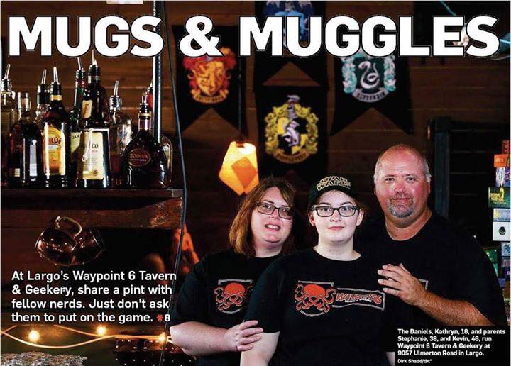 News article about Waypoint 6 Tavern and Geekery with headline Mugs and Muggles. Picture of family standing in front of bar with bottles and shelf of games